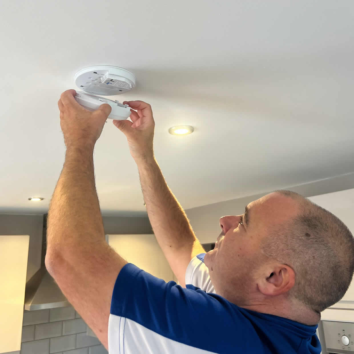 Smoke alarm being installed on a ceiling in Andover